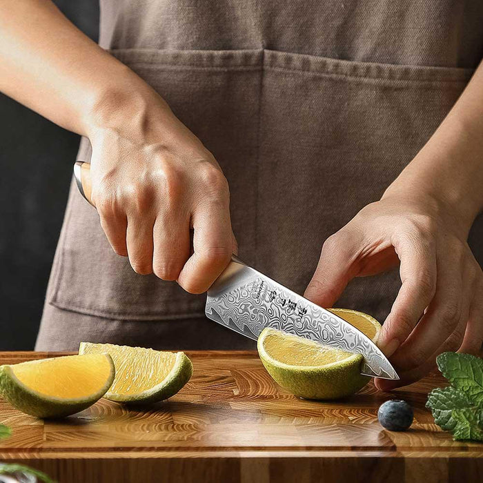 chef cutting fruit with Damascus Utility Knife